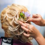 A young woman showcasing a traditional Indian bridal hairstyle for reception, adorned with intricate floral decorations.